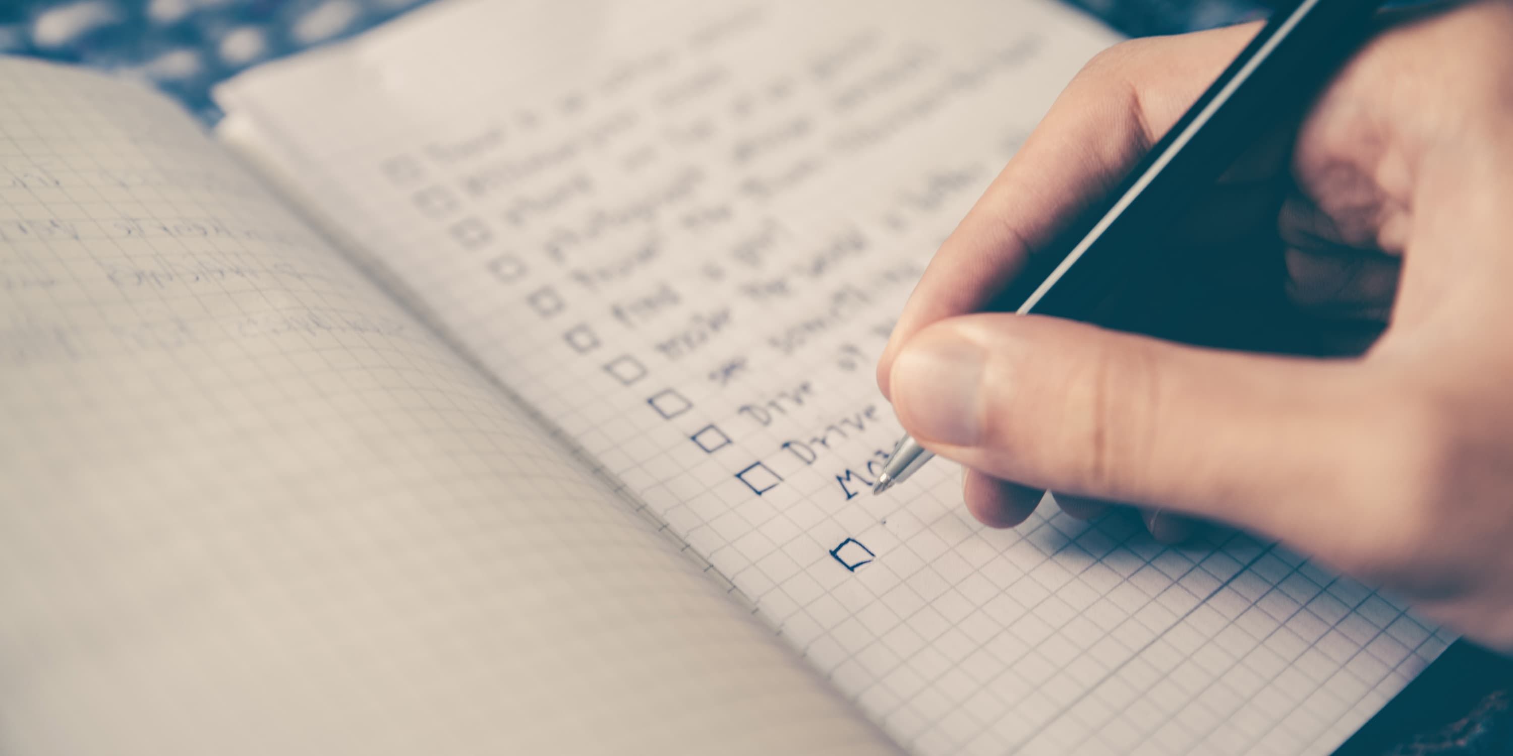 Close up, woman writing packing list