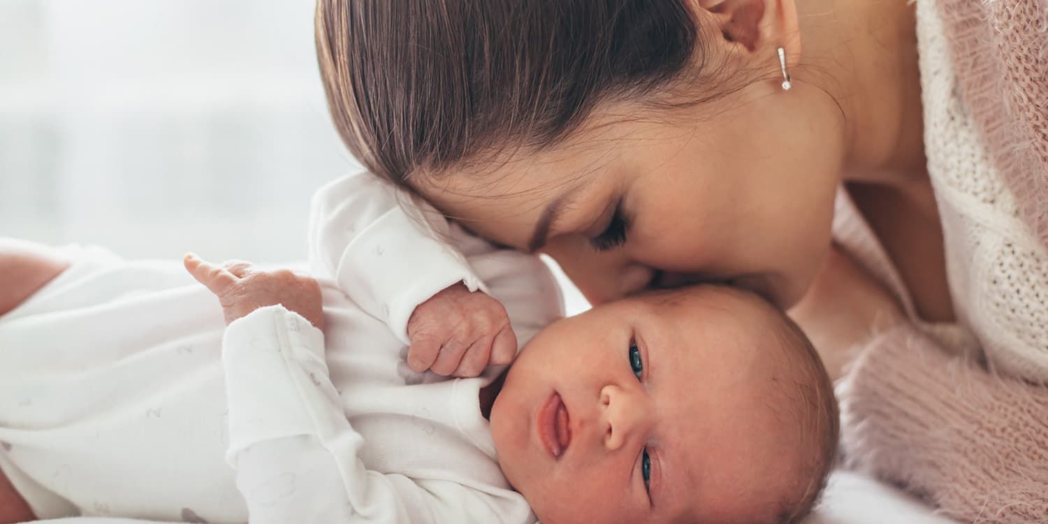 Side view, pregnant woman leans against the wall and puts hands on her belly