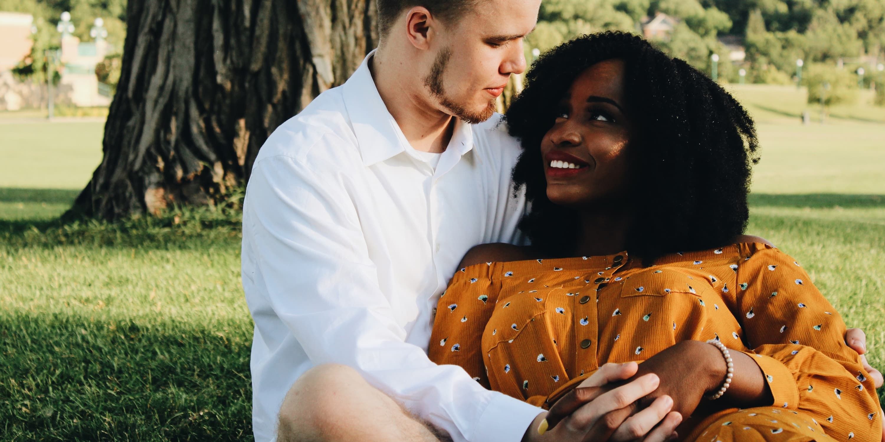 Man cuddles a woman in the park