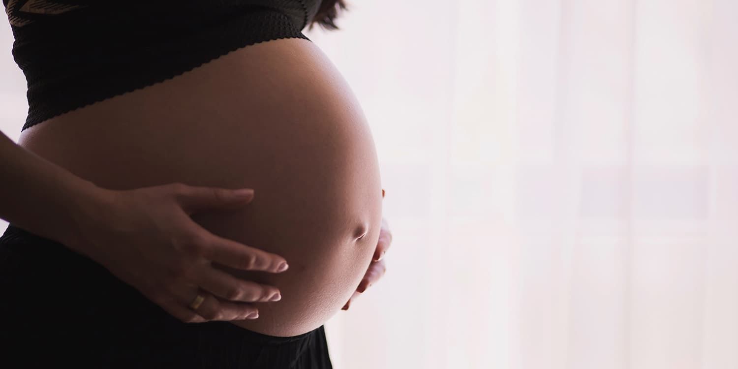 side view pregnant woman with hands on belly