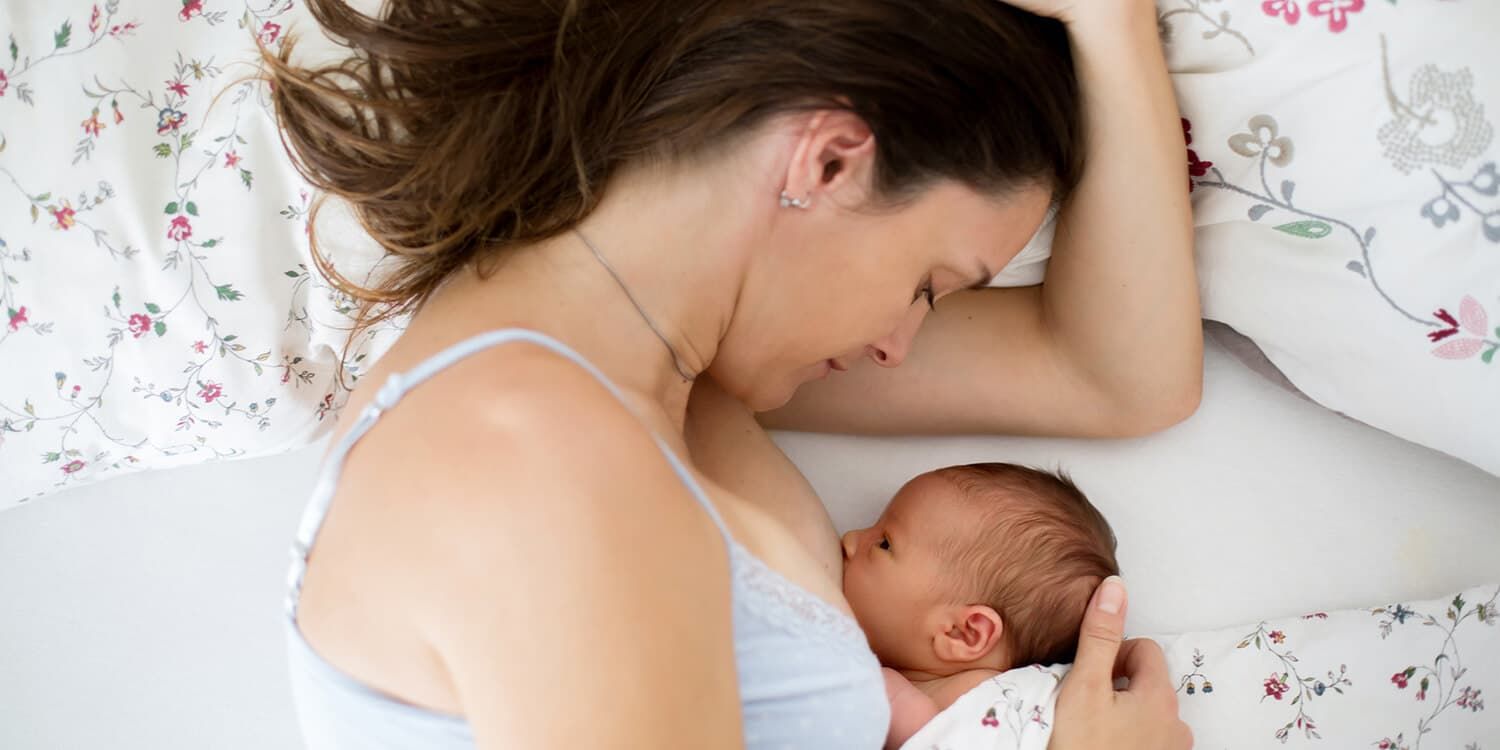 Mother and newborn baby in bed