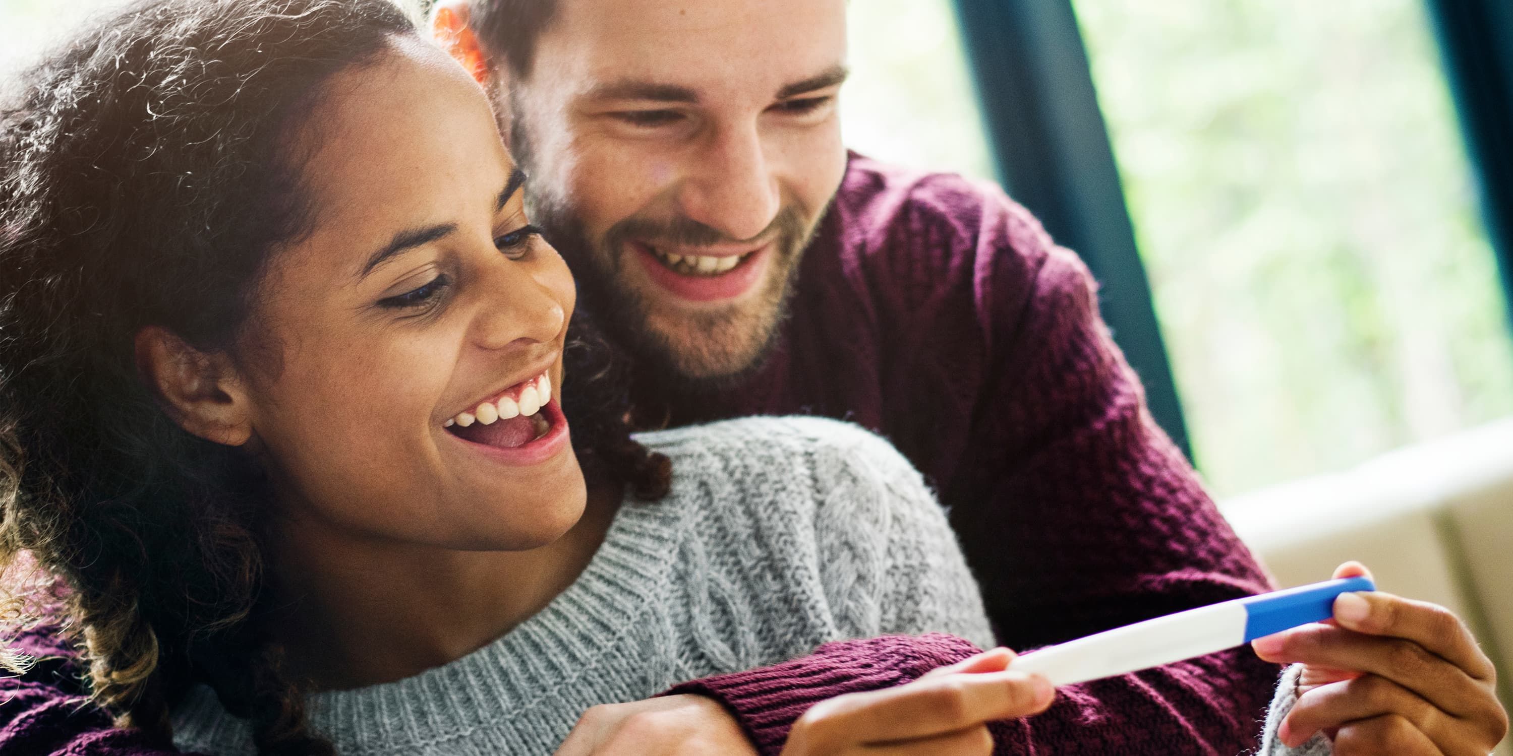 De futurs parents heureux devant un test de grossesse positif